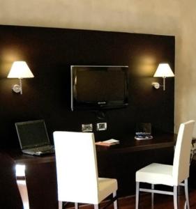 科斯塔桑特阿布拉莫克雷莫纳皇宫酒店 的客房设有一张带笔记本电脑和两把白色椅子的书桌