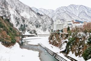 黑部市总庙庄园酒店的山边有积雪的河流