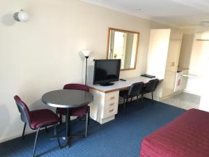 奥兰治奥兰戈汽车旅馆的酒店客房配有带电视和椅子的书桌