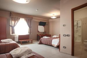 VinchiaturoHotel Ruffirio的酒店客房带两张床和一间浴室