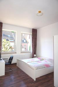 杜塞尔多夫阿图斯酒店的卧室配有白色的床和2扇窗户。