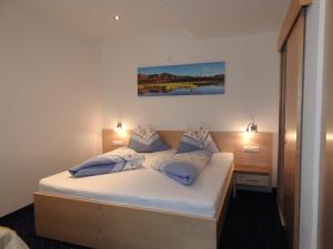 卡普尔Hotel Alpenfrieden的一间卧室配有白色床和蓝色枕头