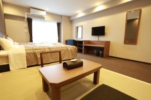 堺市基酒井东公寓酒店 的酒店客房配有一张床铺和一张桌子。