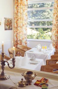 默尔恩荷伦兰瓦尔德霍夫酒店的一间设有两张桌子和窗户的用餐室