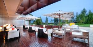 莱里达普拉茨庄园高尔夫水疗酒店的一间设有白色桌子和遮阳伞的餐厅