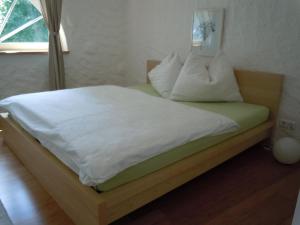 施特罗布尔达尔汉旅馆的一张带白色床单和枕头的床