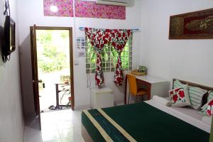 Kampong Chhnang加登旅馆的一间卧室配有一张床、一张书桌和一个窗户。