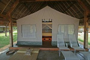 MadirokelyEden Lodge的帐篷配有两把椅子和一张床