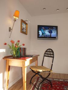 门曾施瓦德赫斯臣酒店的一张桌子、椅子和墙上的电视