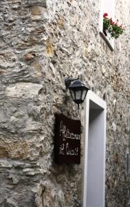 维贾内洛Affittacamere Al Civico 18的一座石头建筑,旁边标有标志
