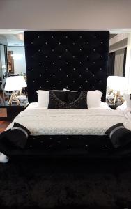 八打灵再也豪华套房度假酒店@双威城的一间卧室配有一张大床和黑色床头板