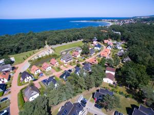 格洛韦Dünenresidenz Glowe - Ferienhaus Maxi 200 m zum Strand的享有村庄的空中景致,设有房屋和海洋