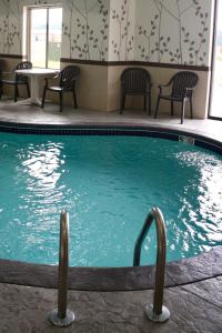 GalionSleep Inn & Suites Galion的游泳池,带椅子和桌子