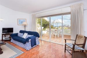卢斯Casa da Praia 98的带沙发和滑动玻璃门的客厅