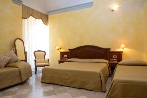 弗拉斯卡蒂Villa Tuscolana的酒店客房,配有两张床和椅子