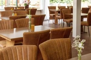 温特斯韦克Hotel Restaurant Mondriaan的用餐室配有木桌和椅子