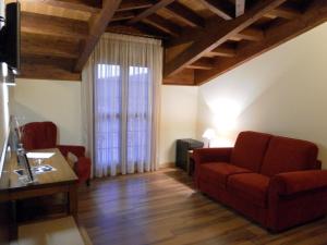 米拉格罗斯米拉格罗斯力拓里亚萨酒店的客厅设有红色的沙发和窗户。