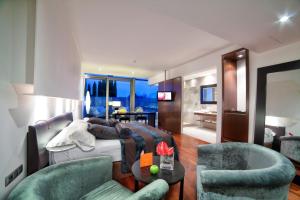 莱里达普拉茨庄园高尔夫水疗酒店的一间带床和两把椅子的卧室和一间客厅