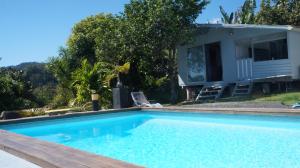 普纳奥亚Bungalow Premium Tahiti的一座带房子的游泳池