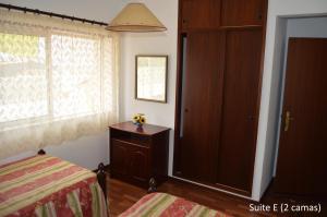 圣马蒂纽·杜·波特Alojamentos dos Mangues的一间卧室配有一张床、一个衣柜和一个窗户。