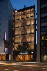 金泽日本金泽胶囊宾馆的夜幕降临的城市街道上一座高楼