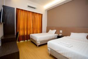 拉布安纳闽财富酒店的酒店客房设有两张床和电视。