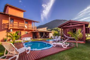 弗洛里亚诺波利斯Green Mountain Pousada的后院设有游泳池、椅子和房屋