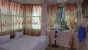 昔卜红龙酒店的一间卧室配有床和带窗帘的窗户