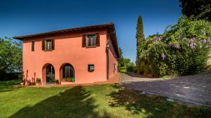 雷杰洛Fattoria Montalbano的一座橘色的房子,有绿色的院子和树木