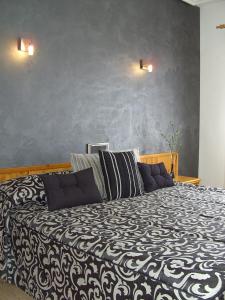 Villaciervos小鹿旅馆的卧室配有黑色和白色的床和2个枕头