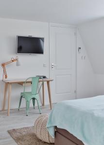 德比尔特Studio De Bilt的一间卧室配有书桌、椅子和床
