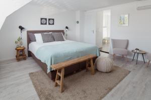 德比尔特Studio De Bilt的一间卧室配有一张带木凳的床。