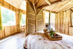 ClaudonLa Clairière du Verbamont的卧室配有一张床铺,位于带木墙的房间内