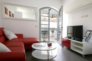 彼得拉桑塔Bonnes Vacances a Pietrasanta的客厅配有红色沙发和电视