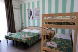 里米尼Beach Hotel Clerice的小型客房配有2张双层床、1张床和1张双层床。