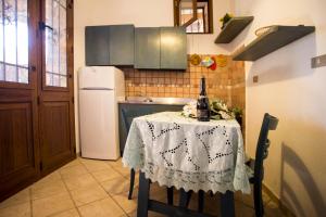 莱乌卡Pietra del Mediterraneo的厨房配有一张桌子,上面放着一瓶葡萄酒