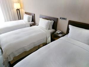 桃园市蜜月世纪大饭店-桃园的酒店客房设有两张床和电话