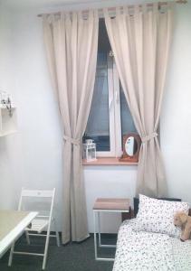 克拉科夫Master Corner Apartment的一间卧室配有床和带窗帘的窗户