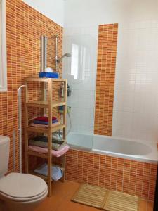 皮拉Sandy Beach Villas 17的带浴缸和卫生间的浴室。