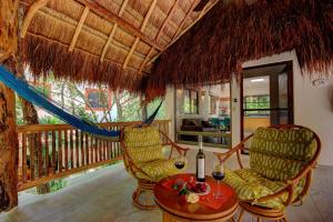 普拉亚卡门玛雅海滨度假套房酒店的门廊上配有两把椅子和一张桌子的房间