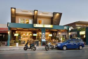 埃亚玛琳娜奈奇多Akatos Hotel的停在商店前的汽车和摩托车