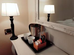 佛罗伦萨卢娜女士住宿加早餐旅馆的桌上装有杯子和咖啡壶的托盘,配有两盏灯