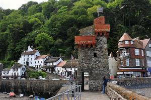 林茅斯Postmans Rest, second floor apartment, Lynmouth with private parking的站在城镇旁边建筑物前面的人