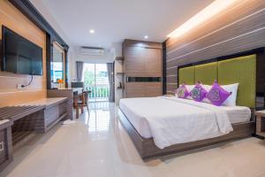 乌汶优杜艾甘花园之家酒店的一间卧室配有一张大床和一台平面电视