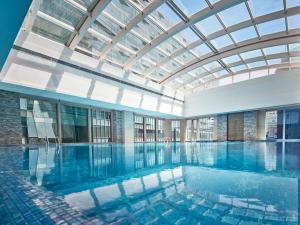 北京北京泛太平洋酒店的一个带玻璃天花板的大型游泳池