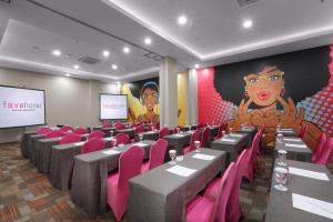索龙索龙非弗酒店的一间会议室,配有桌子、粉红色的椅子和屏幕