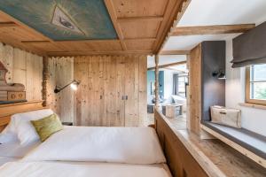 施特拉森Strasserwirt - Ansitz zu Tirol的卧室配有一张床铺,位于带木墙的房间内