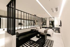 龙仁市伊斯基亚酒店的一间卧室配有一张床和一张黑色沙发