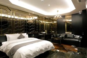 龙仁市伊斯基亚酒店的一间卧室配有一张床、一张沙发和吊灯。