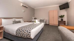 黄金海岸太平洋海岸汽车旅馆的一间卧室配有一张大床和电视